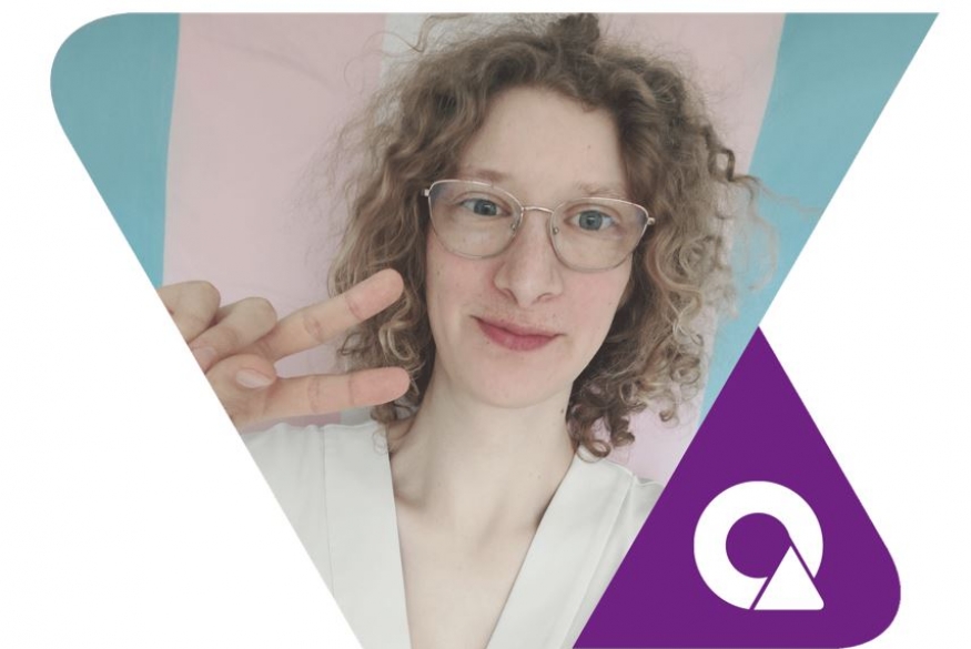 ambassadeur Jenna met in de achtergrond een trans-vlag